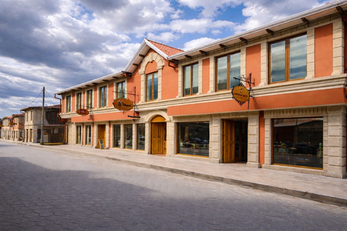 Hotel Jardines de Uyuni exterior with traditional architecture on quiet street in Uyuni Bolivia, captured during a tour with Salar de Uyuni Tours